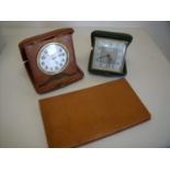 Leather cased travelling 8 day clock, a tan leather aid memoir and another traveling clock (3)