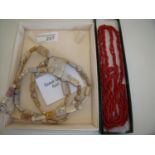 Cased polished sea coral and fossil necklace and a multi-strand coral necklace (2)