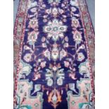Blue ground rectangular Persian pattern woollen rug with central floral panel (103cm x 205cm)