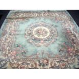 Large beige ground Chinese woollen rug with central floral panel (240cm x 260cm)