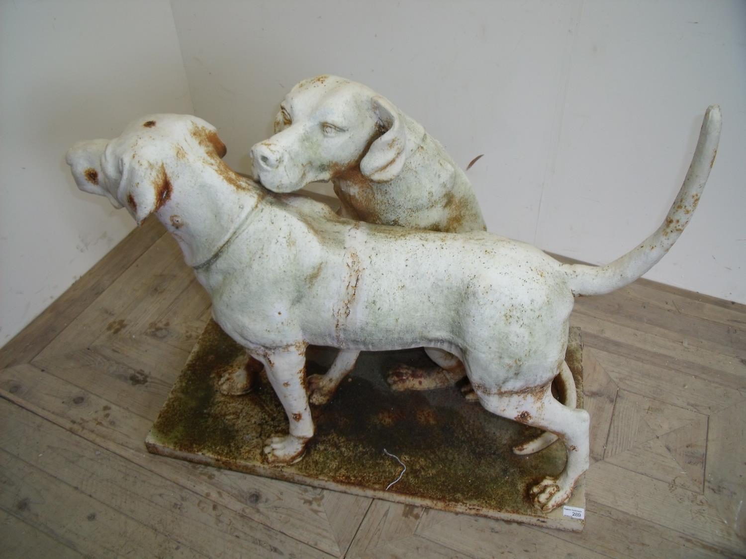 Unusual and large extremely heavy cast metal garden statutory figures of two working dogs, one