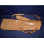 A canvas and tan leather gun slip with carry handles and shoulder strap with fleece lining