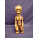 Carved wood African tribal figure of a seated female (31cm high)