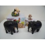 Two ebony carved elephants with painted wood tusks and two boxed Piggin collectable figures