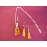 Pair of silver & amber drop earrings with a silver necklace and pendant