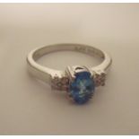 9ct white gold ring set with pale blue stone with four diamond chips to each shoulder