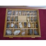 Wooden slope front specimen case with hinged glazed top containing a selection of various assorted