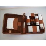 Two-Tix travelling tan dressing case with various silver plated dressing table brushes, jars etc and