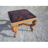 19th/20th C square top coffee table with walnut frame and elaborately carved base with X shaped