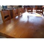 A large heavy oak dining table with X shaped under tier and stretcher (length 240cm) and a set of