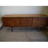 Mid 20th C teak sideboard with four drawers enclosed by two cupboards (width 212cm)