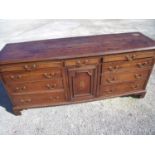 18th/19th C oak dresser base with central drawer above panelled and inlaid cupboard door flanked