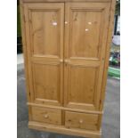 Waxed pine double door wardrobe with two drawers to the base (116cm x 61cm x 195cm)