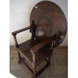 Oak monks style chair with circular tilt top/back with carved detail