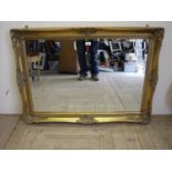 Bevelled edge mirror in ornate gilt frame (width 106cm)