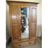 Early 20th C oak single wardrobe with bevelled mirror door and fielded panels above a single drawer