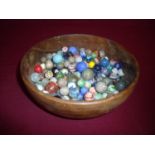 Turned wood bowl containing a large selection of 19th C and later marbles (bowl diameter 21cm)