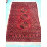 Red ground heavy hand woven Persian rug with three central medallions (196cm x 125cm)