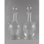 Property of a gentleman - two similar early 20th century glass claret jugs with stoppers, the taller