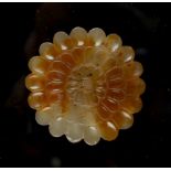 A Chinese carved agate chrysanthemum flowerhead pendant or toggle, 2.8ins. (7.1cms.) diameter (see