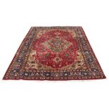 A Tabriz woollen hand-made carpet with dark red ground, 122 by 82ins. (310 by 207cms.) (see