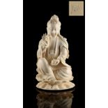 A Chinese carved ivory figure of Guanyin, 19th century, modelled seated on a double lotus base,