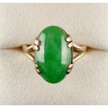 A Chinese apple green jadeite ring, the untreated oval cabochon stone measuring 17.4 by 10.9 mm.,