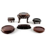 A group of six Chinese carved wood stands, the largest 8.85ins. (22.5cms.) diameter (6) (see