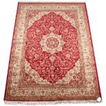 A Kashan style carpet, with red ground, 91 by 63ins. (230 by 160cms.).