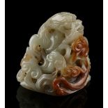 Property of a lady - a Chinese carved celadon & russet jade hat finial with a chilong among lingzhi,