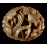 A Chinese russet jade carving modelled as an oval ring with birds among lotus, 3.6ins. (9.1cms.)