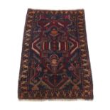 A Belouch prayer rug with navy ground, 60 by 38ins. (152 by 97cms.) (see illustration).