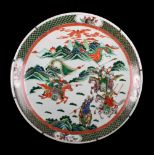 A large Chinese famille verte charger, late 19th / early 20th century, painted with warriors on
