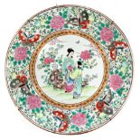 A Japanese famille rose charger, circa 1900, painted with two bijin in a garden, within a border