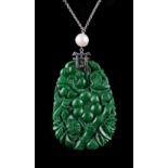 A Chinese carved untreated jadeite pendant depicting flowers & bamboo, the white metal mount with