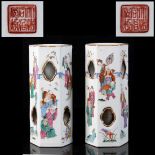 A pair of Chinese famille rose wig stands, of pierced hexagonal form, painted with figures, iron red