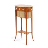 An Edwardian gilt metal mounted satinwood oval two-tier work table, the frieze set with eight neo-