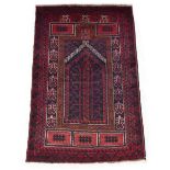 A Belouch rug with dark red ground, 59 by 36ins. (150 by 91cms.) (see illustration).