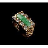 A 14ct yellow gold jadeite & diamond ring, the round ended rectangular jadeite panel flanked by