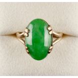 A Chinese apple green jadeite ring, the untreated oval cabochon stone measuring 17.4 by 10.9 mm.,