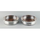 Property of a lady - a pair of silver plated coasters with turned wooden bases, each 5.5ins. (