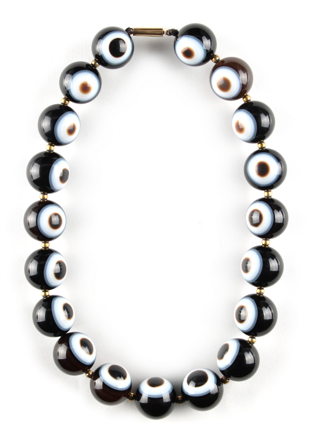 An 'eye' agate bead necklace, the nineteen uniform beads each approximately 20mm diameter, 18.