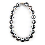 An 'eye' agate bead necklace, the nineteen uniform beads each approximately 20mm diameter, 18.