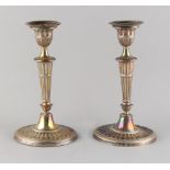 Property of a lady - a pair of Edwardian neo-classical silver candlesticks, of fluted oval form,