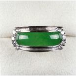 An 18ct white gold untreated jadeite & diamond ring, set with a curved & rounded jadeite panel