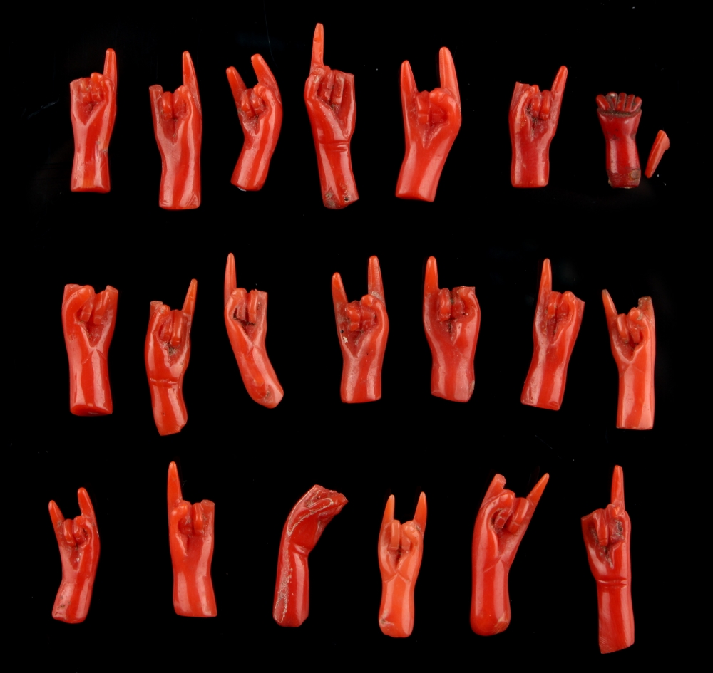 A group of twenty carved coral models of hands, probably 19th century, each approximately 20mm