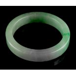 A heavy Chinese jadeite bangle, with apple green & lavender inclusions, 3.15ins. (8cms.) diameter (