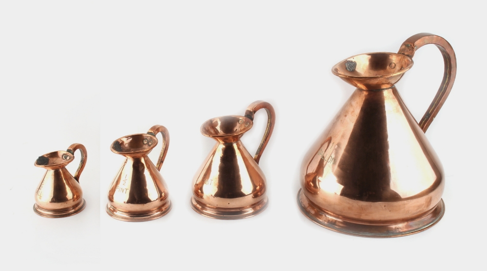 Property of a lady - a graduated set of four copper 'haystack' measuring jugs, the largest 1