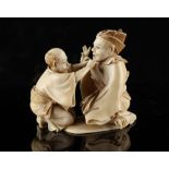 A Japanese carved ivory okimono depicting two seated figures, Meiji period (1868-1912), signed Ryoko