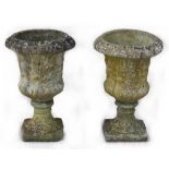 Property of a deceased estate - a pair of well weathered reconstituted stone two-part garden urns,